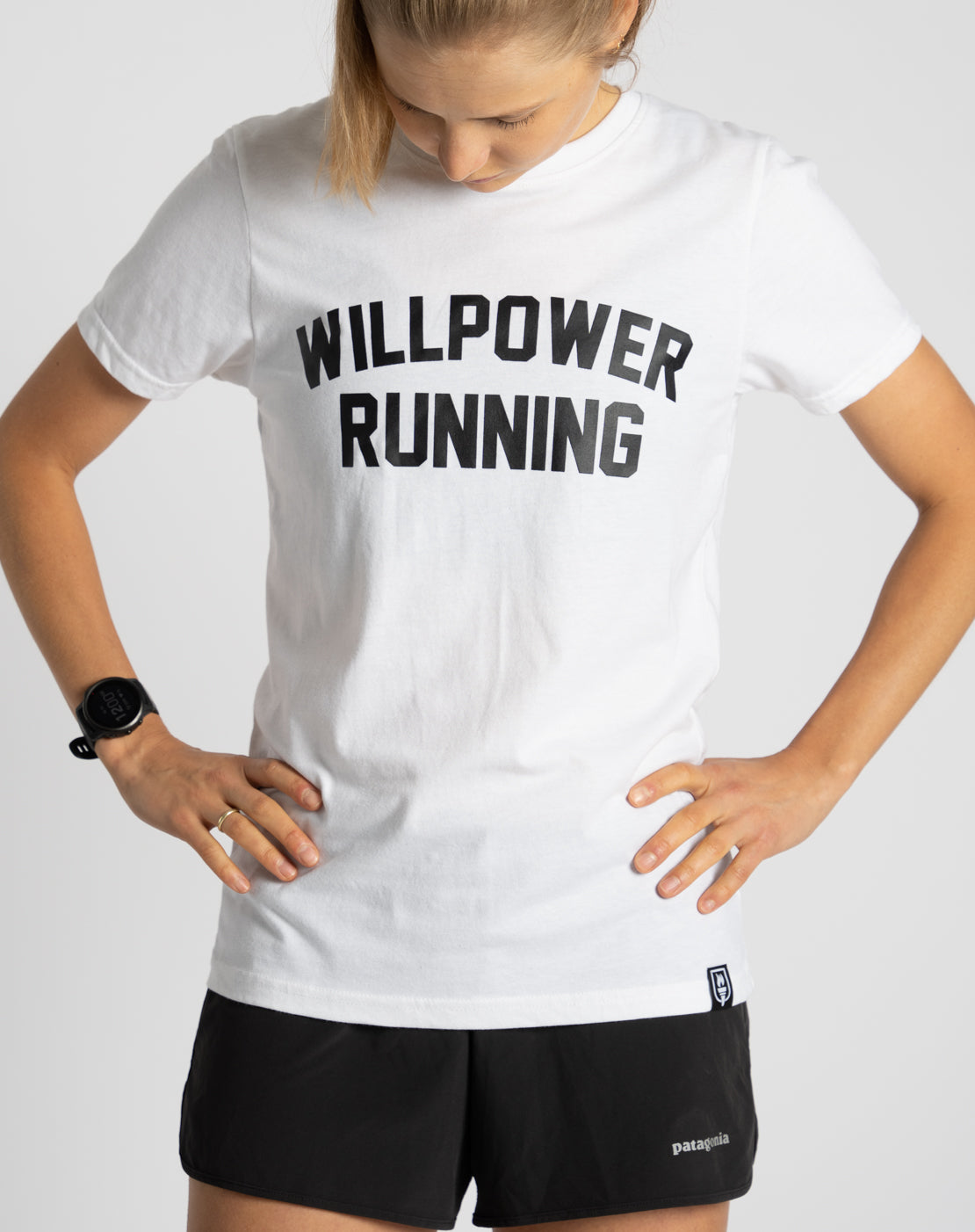 Person wearing a white 'WILLPOWER RUNNING' t-shirt on a plain background