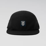 A black five-panel camp cap with a small rectangular embroidered patch on the front featuring a white flame and the word 'SUNRISE' on a dark navy background, set against a light gray gradient studio background.
