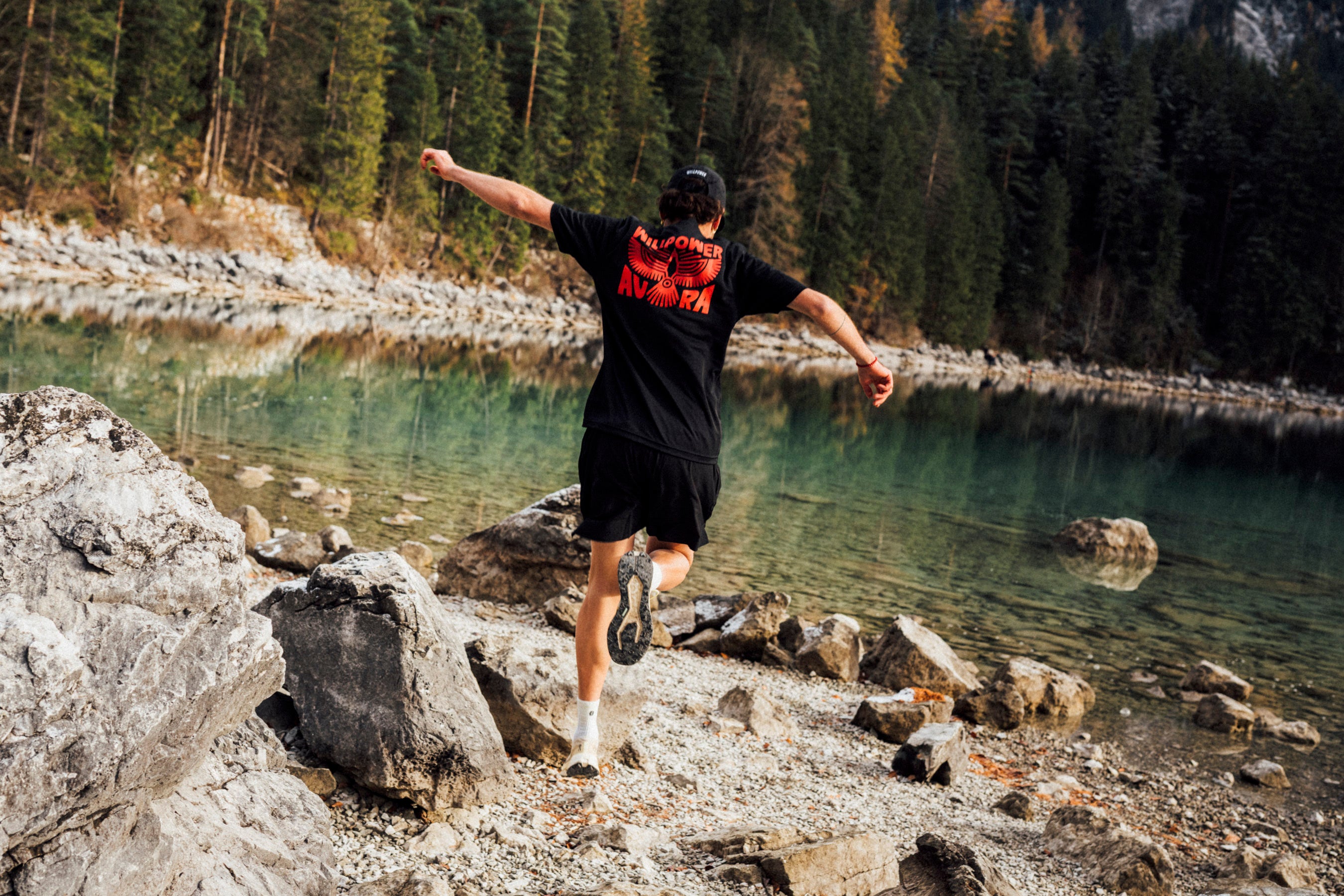 Person running towards a lake with trees in the background