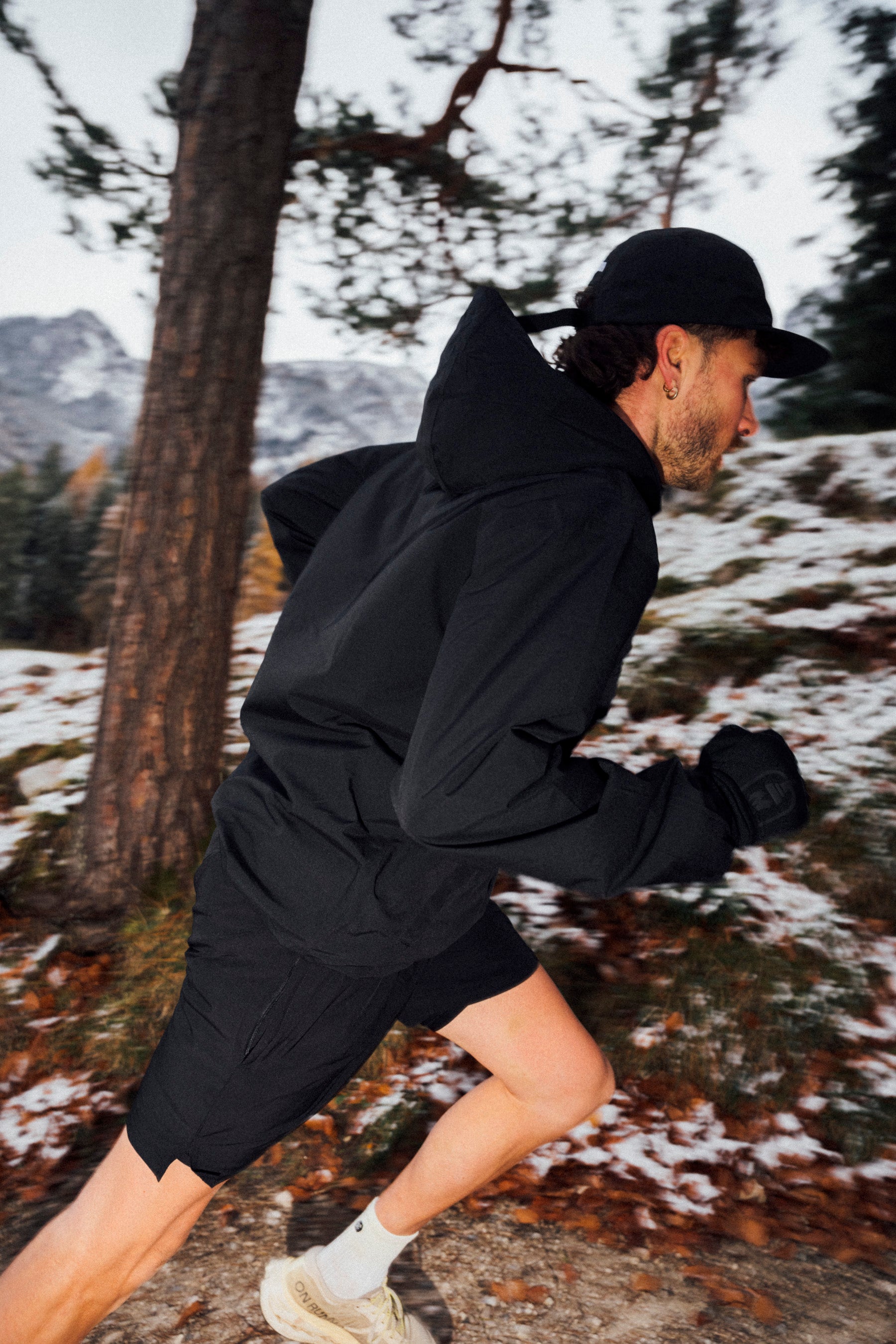 Person running outdoors in a forest with snow on the ground